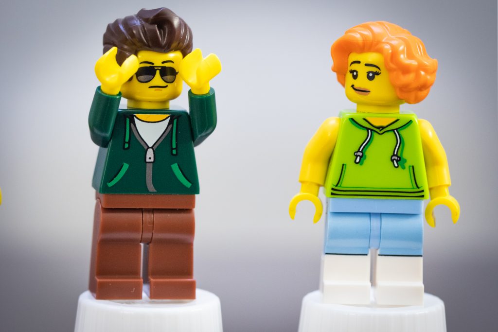 two lego figures standing on pedestal with one looking like a champ