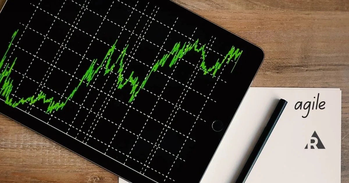 laptop with Graphs and and notepad with word agile on it
