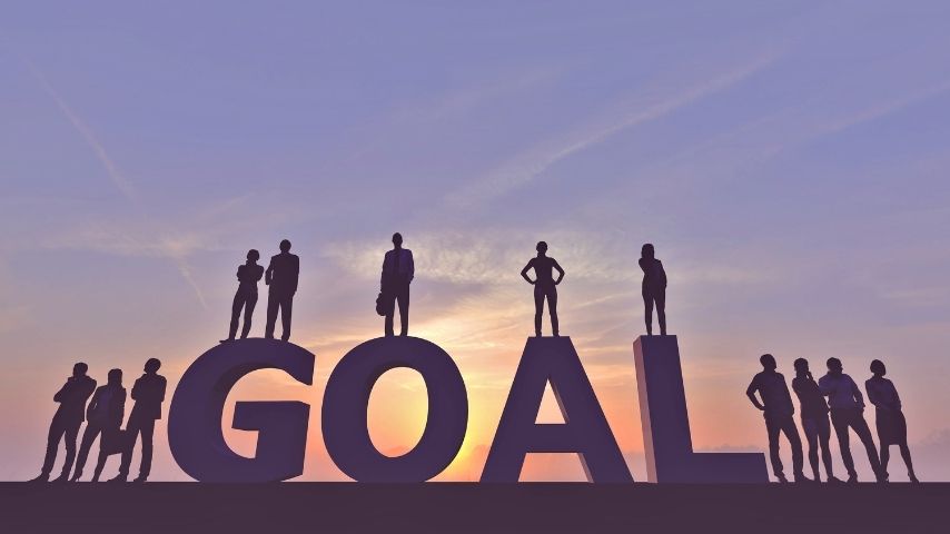 business people standing on the word goal