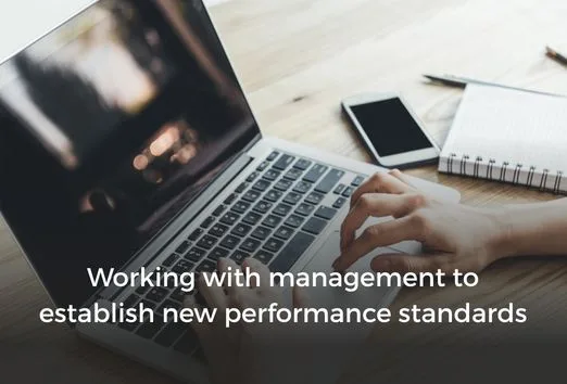 Working with management to establish new performance standards man working on laptop