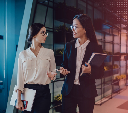 two women two women in an office talking and walking