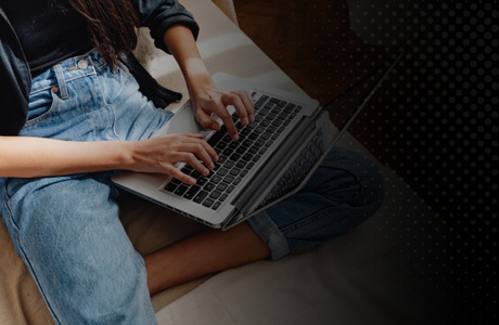 women sitting on couch on laptop